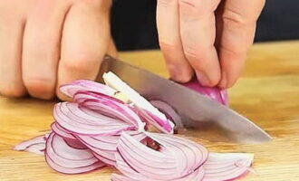Gumagamit kami ng mga lilang sibuyas para sa salad.Kung hindi ito ang kaso, gumamit ng isang regular na sibuyas. Una ay tinanggal namin ang layer ng husk at pagkatapos ay i-cut ito sa mga piraso.