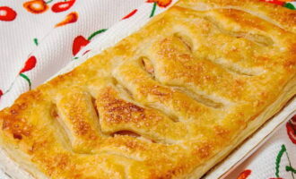 Painitin ang oven sa 220 degrees. Gupitin ang dalawang sheet mula sa isang roll ng baking paper. Ilagay ang mga ito sa isang baking sheet at ilagay ang mga pie. Hatiin ang itlog. Talunin ito ng isang whisk at grasa ang mga inihurnong gamit gamit ang isang pastry brush. Maghurno ng mga pie sa loob ng 20-25 minuto. Palamigin at ihain. 