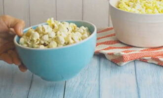 Nadat de bonen niet meer stuiteren, verwijdert u het deksel en giet u de hete popcorn onmiddellijk in een droge kom.