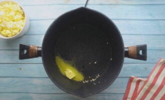 Smelt vervolgens een eetlepel boter in deze hete koekenpan en bestrijk de hete popcorn er gelijkmatig mee. De olie kan worden verwarmd tot deze lichtbruin is, wat een rijke smaak aan de popcorn zal toevoegen.
