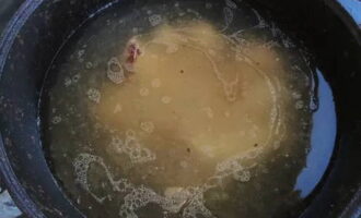 Susunod, ilipat ang karne ng baka sa isang kaldero, punan ito ng malamig na tubig, ilagay ito sa apoy at lutuin ng 2.5 oras, pana-panahong pag-skimming off ang nagresultang foam.