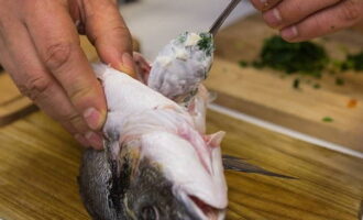 Vi lägger grönsaker blandade med grönsaker i magen på laken och strö själva fisken med salt, kryddor efter smak och smörj med vegetabilisk olja på alla sidor.