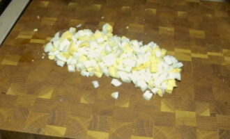 Com preparar una amanida senzilla i saborosa amb escabetx? Els ous durs es pelen i es tallen a daus petits.Hi ha una regla no expressada a l'hora de tallar aliments per a amanida: la mida de les peces ha de ser igual a la mida dels pèsols.
