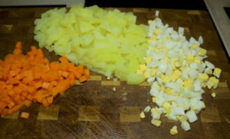 Les patates i les pastanagues bullides es pelen i es tallen en els mateixos daus petits que els ous.