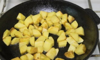 Schil en snijd op dit moment de aardappelen in grote stukken en bak ze in een kleine hoeveelheid olie tot ze lichtbruin zijn.