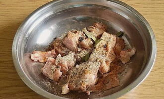 Transferiu el pollastre a un recipient profund, afegiu sal, all sec, pebre de Jamaica, pebre negre mòlt, grans de pebre, llorer i condiments de pollastre. Peleu les cebes, talleu-les a trossos petits i envieu-les a la carn. Barrejar-ho tot bé. 