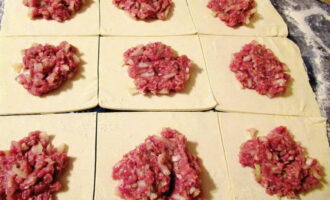 Col·loqueu el farcit al centre de cada tros de massa i pessigueu les vores amb força per formar quadrats o triangles. És important fer-ho perquè el suc no surti durant la cocció.