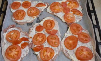 Maglagay ng manipis na hiwa ng mga kamatis sa mga chops at magdagdag ng asin kung kinakailangan.