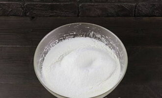 Trộn 200 gam bột mì với soda và bột nở - rây qua rây có lỗ mịn cho thẳng vào đĩa cùng các nguyên liệu đã chuẩn bị sẵn.