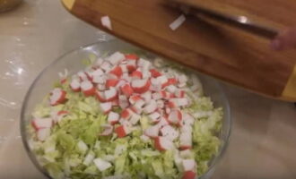 Bastoanele de crab de înaltă calitate, decongelate în prealabil, sunt scoase din ambalaj și tăiate în cuburi subțiri.