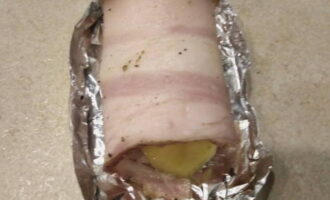 Es formen plaques amb paper d'alumini i s'hi col·loquen patates i cansalada, 1-2 peces alhora. La part superior es deixa oberta per a una cocció bonica.