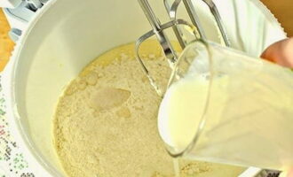 Voeg, zonder op te houden met het werken met gardes, een glas kefir toe en kneed het deeg tot een glad mengsel.