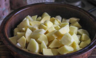 Les patates amb bolets al forn es preparen de manera ràpida i senzilla. Pelem aproximadament 600 grams de patates i les esbandim bé amb aigua corrent, després les tallem a trossos de mida mitjana i les posem en olles porcions aptes per al forn.