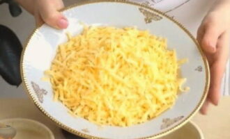 Cum să gătești cartofii în oale cu carne și ciuperci la cuptor? O bucată de brânză tare se zdrobește pe răzătoarea grosieră.