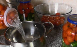 După un sfert de oră, turnați apa din borcane printr-un capac special în tigaie și determinați-i volumul pentru prepararea corectă a marinadei.