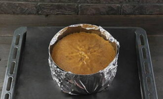 We behandelen het koekje gedurende 40 minuten met warmte. Controleer de bereidheid met een tandenstoker. Haal de hete bakwaren uit de oven en laat ze op kamertemperatuur staan ​​totdat ze volledig zijn afgekoeld, zonder ze uit de splitring te halen.