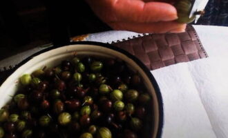 Ang limang minutong gooseberry jam para sa taglamig ay napakadaling ihanda. Para sa jam, pumili ng mga hilaw na gooseberry ng anumang kulay o kumuha ng pinaghalong mga berry. Gamit ang matalim na gunting, alisin ang mga dulo ng bawat berry. Pagkatapos ay banlawan ng mabuti ang mga gooseberries ng malamig na tubig at iwaksi ang labis na likido sa isang colander.