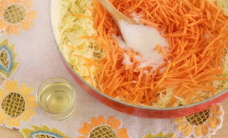 Adăugați o lingură de zahăr în varza caldă și amestecați până se dizolvă.Apoi turnați trei linguri de ulei vegetal și amestecați din nou.