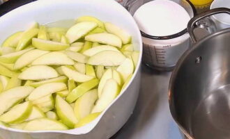 Fer melmelada de poma per a l'hivern és molt senzill. Rentar bé les pomes seleccionades per cuinar i treure les beines de llavors. Aboqueu 3 litres d'aigua freda en un bol per fer melmelada i dissoleu-hi 1/3 culleradeta d'àcid cítric. Talleu les pomes a rodanxes fines iguals i poseu-les en un bol amb aigua. L'àcid cítric evitarà que les pomes s'enfosquin.
