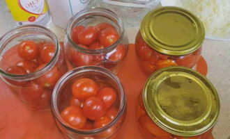 Steriliseer literpotten vooraf en kook de deksels. Doe de voorbereide tomaten in potten, giet er kokend water overheen en laat de potten afgedekt met deksels 20 minuten staan. Steriliseer literpotten vooraf en kook de deksels. Doe de voorbereide tomaten in potten, giet er kokend water overheen en laat de potten afgedekt met deksels 20 minuten staan.