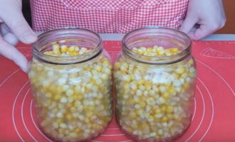 Esbandiu bé els pots per a la preparació amb refresc i esterilitzar-los juntament amb les tapes amb qualsevol mètode. Col·loqueu els grans de blat de moro en pots preparats. 