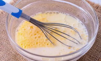 Ibuhos ang langis ng gulay (1 tbsp) at gatas sa temperatura ng silid sa pinalo na mga itlog. Paghaluin nang mabuti ang mga sangkap na ito gamit ang isang whisk.