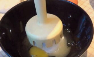 Rupeți ouăle de pui într-un castron separat, adăugați zahăr și bateți cu un blender submersibil într-o masă pufoasă, omogenă.