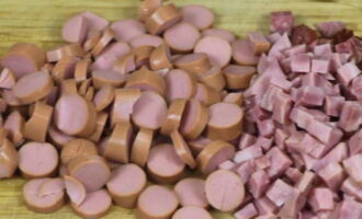Trong thời gian này, hãy cắt bộ sản phẩm thịt được chỉ định trong công thức solyanka cổ điển thành những khối nhỏ và cắt xúc xích thành những vòng tròn mỏng. Chuyển các lát sang một bát riêng.