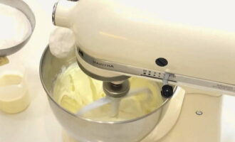 Fără a opri aparatul, turnați 200 g de zahăr pudră în brânză.