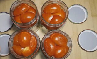 A continuació, col·loqueu compactament les rodanxes de tomàquet als pots, talleu-les cap avall i disposeu-les amb rodelles de ceba.