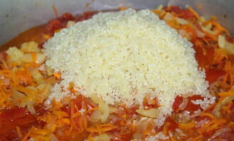 Pagkatapos ng kalahating oras, ilipat ang bigas sa mga gulay, pukawin muli at pakuluan ang salad nang hindi bababa sa 1 oras sa mababang init, nang hindi tinatakpan ito ng takip at paminsan-minsang pagpapakilos gamit ang isang kahoy na spatula.