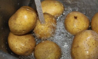În mod ideal, în această rețetă ar trebui folosiți cartofi noi cu coajă. Clătiți bine ingredientul sub jet de apă.
