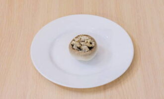 Nhồi chặt nắp champignon với hỗn hợp thu được.