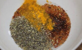 Într-un castron adânc, combinați boia de ardei, turmeric și ierburi de Provence.