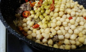 Afegiu cigrons bullits a la carn, amaniu-los amb comí, cúrcuma i llúpol suneli. Esbandiu el pebrot i talleu-lo en anelles, afegiu-lo al plat segons les vostres preferències de gust.