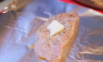 Verdeel bakfolie op een bakplaat, leg er een stuk kalkoenvlees op en leg er een stuk boter op. Boter geeft het vlees malsheid en sappigheid.
