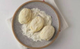 Se amestecă bine oul. Pune faina de grau pe o farfurie. Formați cocoloașe de aproximativ aceeași dimensiune din terci de gris. Aplatizați cu mâna și pâinea pe toate părțile în făină.