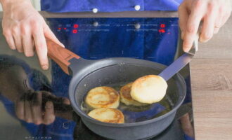 Escalfeu una paella amb oli vegetal. Fregiu els pastissos de formatge aquí pels dos costats fins que estiguin daurats.