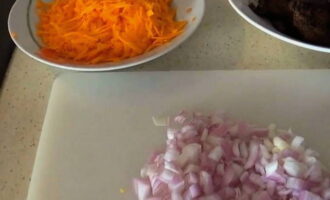 Medan levern steker, skal du löken och morötterna. Skär löken i tärningar och hacka morötterna på ett grovt rivjärn.