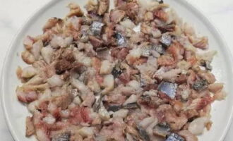 Hur förbereder man en läcker sallad med sill? Skala den lättsaltade sillen från skalet och separera filéerna från benen. Förbered rätten för montering. Hacka filén i tärningar och lägg i det första lagret.