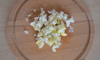 Ang bean salad ay napakadaling ihanda. Pakuluan ang mga itlog ng manok. Pagkatapos naming palamig ang mga ito, alisan ng balat ang mga ito at gupitin sa maliliit na cubes.