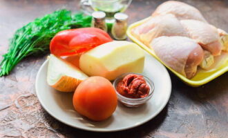 Adunați ingredientele din listă. Spălați cartofii și curățați-i cu un curățător de legume. Spălați și uscați roșiile, ierburile și ardeii dulci. Clătiți puiul și despărțiți-l în bucăți. Lăsați bețișoarele și gătiți un bulion bogat din restul cărnii. Gatiti aproximativ 2 ore la foc mic.