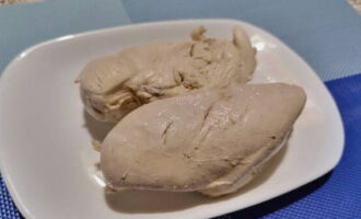 Ang salad na may mga adobo na mushroom ay napakadaling ihanda. Pakuluan ang fillet ng manok hanggang maluto at hayaang lumamig.
