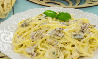 Pasta met zeevruchten in romige saus is klaar. Zet de schaal op borden en serveer.