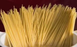 Zet de pan op het vuur, zet het vuur op maximaal en wacht tot het kookt. Zout en giet plantaardige olie erin. Roer en voeg spaghetti toe.