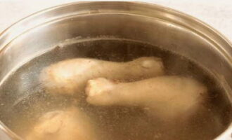 ล้างขาไก่หรือน่องไก่. วางในกระทะทรงลึก เติมเกลือเล็กน้อย เทน้ำวางบนเตาแล้วนำไปต้ม อย่าลืมเอาโฟมที่ก่อตัวออกด้วย ปรุงอาหารด้วยไฟปานกลางปิดฝา