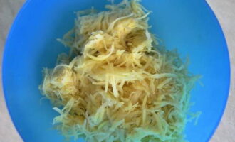 Ratlleu les patates preparades en un ratllador gruixut. Col·loqueu la barreja en un bol profund. Si la verdura ha donat molt suc, esprémer lleugerament el líquid.
