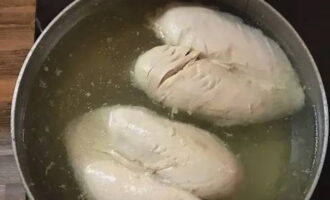 ล้างอกไก่ ลอกหนังออก แล้วใส่ในกระทะ เติมน้ำ. วางบนเตาแล้วนำไปต้มที่อุณหภูมิปานกลาง ใช้ช้อนมีรูตักโฟมออก ปิดฝาแล้วปรุงด้วยไฟอ่อนประมาณหนึ่งชั่วโมง ทิ้งเนื้อที่เสร็จแล้วไว้ในน้ำซุปจนเย็นสนิท