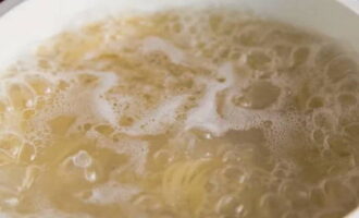 Geleidelijk aan wordt de spaghetti nat en gaat onder water. Hier moet je ze een beetje helpen met een lepel. Wanneer de pasta volledig in water is ondergedompeld, breng opnieuw roerend aan de kook. Kook 1-2 minuten minder dan de instructies op de verpakking.