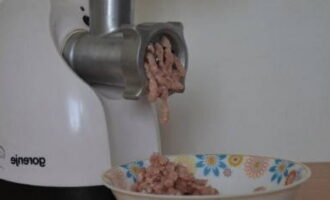 Folosind o mașină de tocat carne, măcinați un sfert din bucățile de pui. Am un aparat electric, așa că iese repede. Puteți adăuga câțiva căței de usturoi dacă doriți, dar eu folosesc usturoi uscat.
